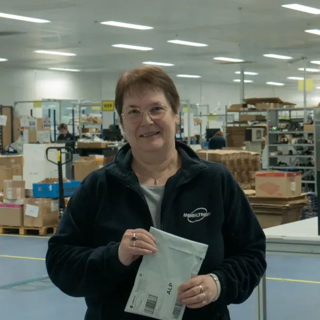 Un employé souriant devant la chaine logistique/A smiling employee in front of the supply chain